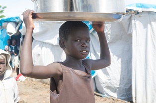 A young girl carrying water at the Tomping civilian protection site. Juba, South Sudan; May 2014. 