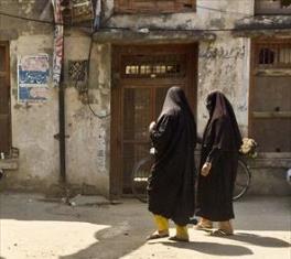 Pakistani women, in the traditional burqa, returning home from their morning visit to the local shops. April 23, 2014 