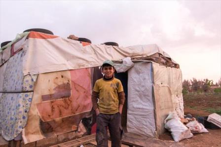A Syrian boy in front of his tent in Bekaa valley, Lebanon. His family fled the civil war. He now works as a car mechanic to earn money to pay for the plot of land for his tent. March 2014 