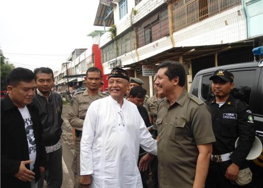 All smiles: A Muslim leader shares a joke with local police officers after protests in West Java that secured the closure of four churches.
