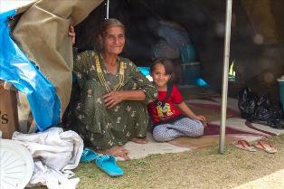 A grandmother and her granddaughter in a tent at a church in Erbil. August 20, 2014 