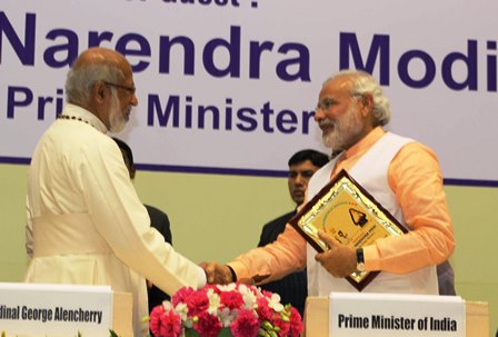 Indian Prime Minister Modi shakes hand wtih Cardinal Alencherry while holding a memento of twin saints 