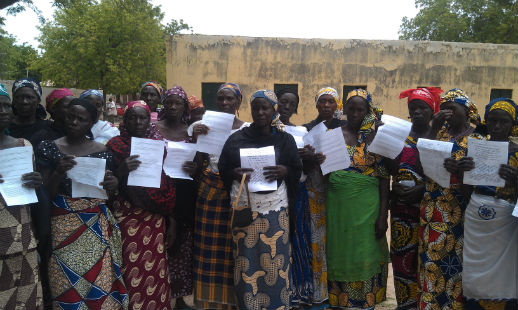 Parents of some of the girls kidnapped from their school in Chibok, Nigeria, in April 2014 hold up letters of support and prayers, provided by Open Doors International, in August 2014.
