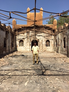 Rev. Jacques Kangindé stands alone inside the remains of his 'Roundabout' church.