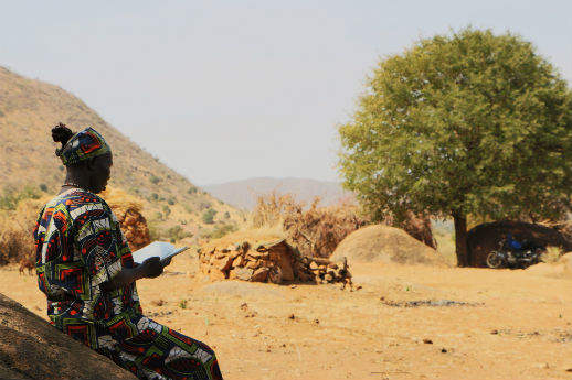 A woman reads a Bible in the Nuba Mountains
