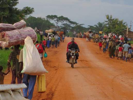 Thousands flee a village in Ituri, taking everything they can carry, after an attack on 6 May. One local said people could be seen fleeing across an area of about 12km.
