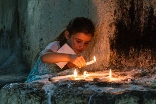 A young girl lights a candle in an artificial cave at Mar Elia church, Ankawa (Irbil), where many displaced Christians have taken refuge. 