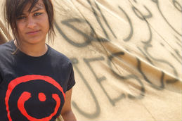 A young woman wears the 'nuun', the letter 'n', which Islamic State daubed on Christian homes.