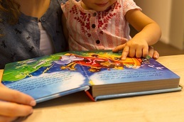 Kristina and
 her daughter read a children's story.