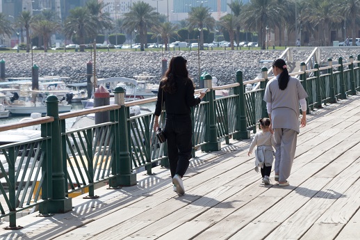 An Asian woman keeps close watch of a Kuwaiti girl as she walks a few steps ahead of her mother.