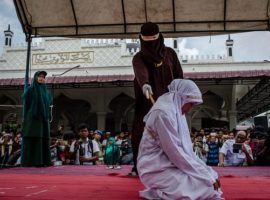An woman in Indonesia's Banda Aceh gets caning in public from an executor known as 'algojo' for spending time with a man who is not her husband, which is against Sharia law on March 20, 2017. Aceh Province is the only place in the Muslim-majority country which implements the strict version of Sharia Law. In a move to stop the rise of radical Islamist groups, the Indonesian government has adopted a law that will make disbanding such groups easier. (Photo: Getty Images)