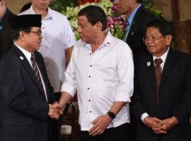 Philippine President Rodrigo Duterte (C) shakes hands with Al-Hajj Murad (L), chairman of the Moro Islamic Liberation Front (MILF), as Ghazali Jaafar (R), vice chairman of MILF, looks on during a ceremony where a draft of the Bangsamoro Basic Law (BBL) was submitted to the president at the Malacanang Palace in Manila on July 17, 2017. (Photo: Getty Images)