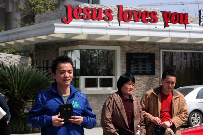 A Chinese Christian holds a Bible standing outside the largest Chinese church in the world: the Three Self church which seats 5,000 people, in Hangzhou city.