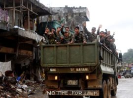 Soldiers on a military vehicle are seen on liberated but battle damaged street in Marawi City on 17 October. (Photo: Getty Images)