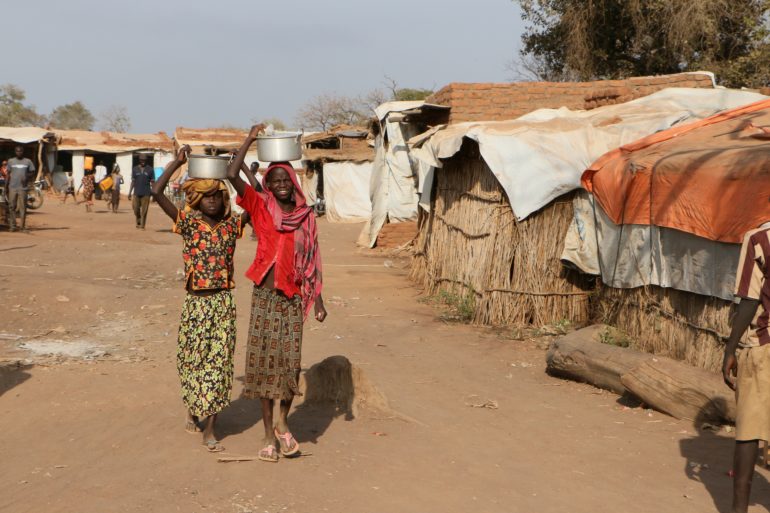 Teenage girls carry water in a refugee camp for people from the Nuba Mountains in Sudan. (Photo: World Watch Monitor)