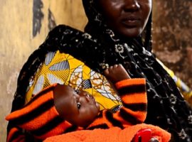 Boko Haram survivor Esther*, holding her daughter Rebecca in her arms. (Photo: World Watch Monitor)
