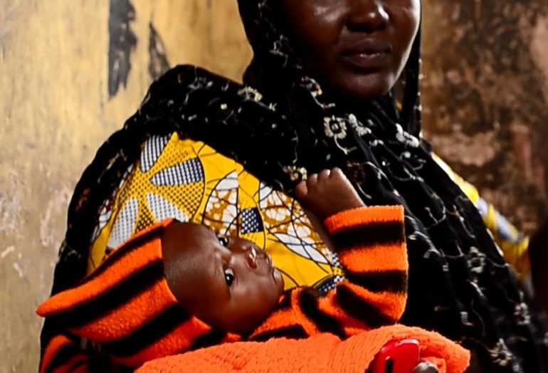 Boko Haram survivor Esther*, holding her daughter Rebecca in her arms. (Photo: World Watch Monitor)
