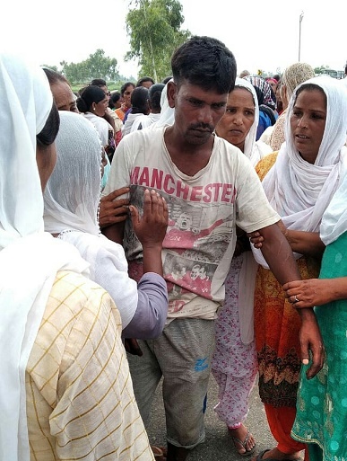 The girl's father is comforted by local women (World Watch Monitor)