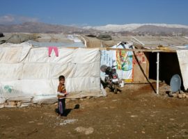 Boy outside a tent in a refugee camp in Lebanon. (Photo: World Vision)