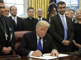 US President Donald Trump signs the "Iraq and Syria Genocide Relief and Accountability Act of 2018" in the presence of, among others, Archbishop Bashar Warda of Erbil, Iraq (l). (Photo: Getty)